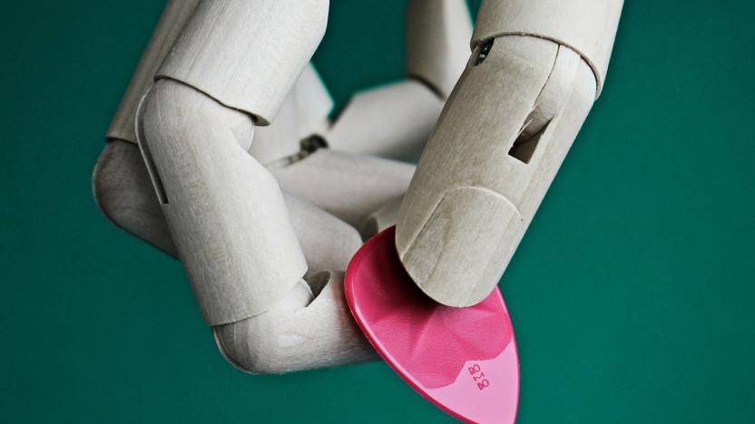 A robot hand holding a guitar pick.