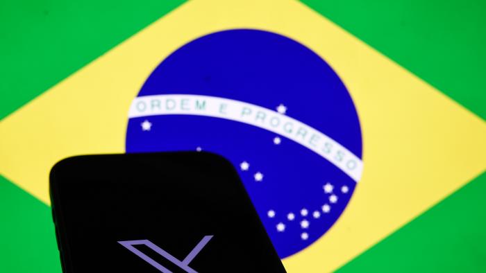 Brazilian flag displayed on a laptop screen and X logo displayed on a phone screen are seen in this illustration photo taken in Krakow, Poland on September 2, 2024. (Photo by Jakub Porzycki/NurPhoto via Getty Images)