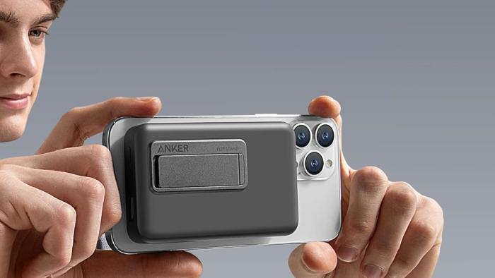 Anker 633 MagSafe-enabled charger attached to an iPhone that someone is holding as if they're framing a photo.