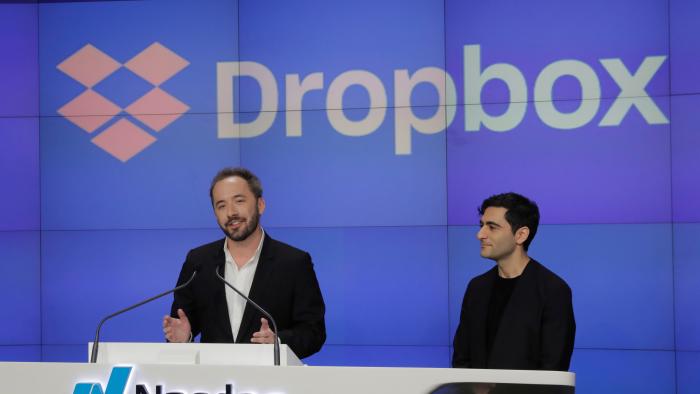 Dropbox Inc. co-founder Drew Houston speaks in front of co-founder Arash Ferdowsi celebrate as Dropbox (DBX) is listed for the company's initial public offering (IPO) at the Nasdaq Market Site in New York, U.S., March 23, 2018.  REUTERS/Lucas Jackson