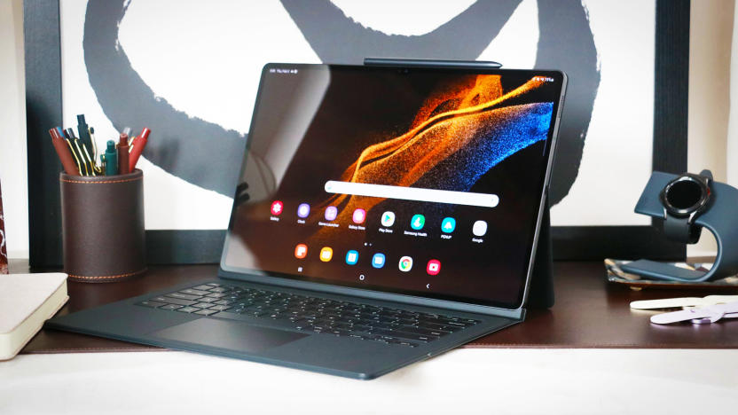 The Galaxy Tab S8 Ultra with a keyboard case and kickstand, placed on a table. An S Pen sits on the top edge, appearing to be magnetically attached.