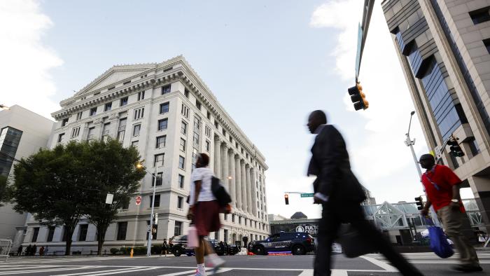 FILE - People cross the street near the Fulton County Courthouse, Aug. 14, 2023, in Atlanta. Court and other systems in Fulton County, Georgia's most populous county, were hacked over the weekend, resulting in interruptions to routine operations, officials said Monday, Jan. 29, 2024, adding that the racketeering case against former President Donald Trump is unaffected. (AP Photo/Alex Slitz, File)