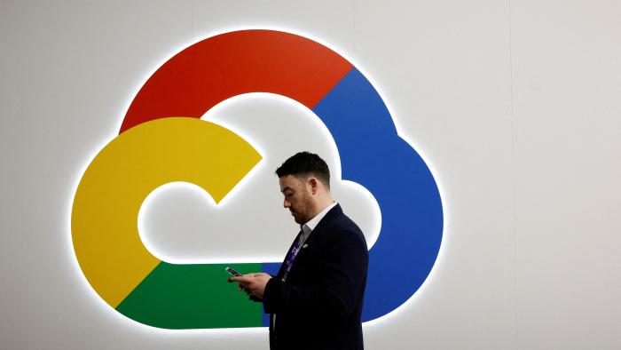 A person looks at their phone in front of the Google Cloud logo, at the 2024 Mobile World Congress (MWC) in Barcelona, Spain February 27, 2024. REUTERS/Albert Gea